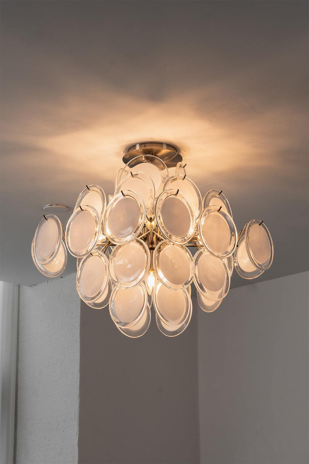 Mirella Circular Glass Pane Ceiling Light | Studio Lit View | Fully lit studio presentation of the circular glass pane fixture casting a warm golden light halo on a grey ceiling backdrop | vexa lamps