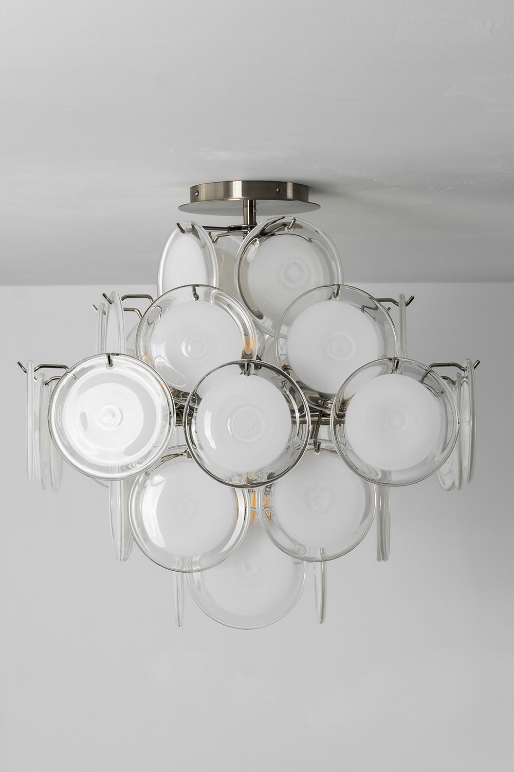 Mirella Circular Glass Pane Ceiling Light | Studio Unlit View | Studio perspective shot of the unlit semi-flush ceiling light displaying its elegant white glass disc silhouette against a grey wall | vexa lamps
