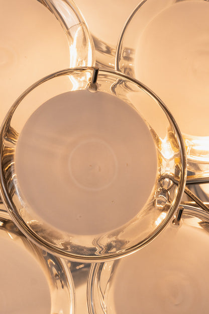 Mirella Circular Glass Pane Ceiling Light | Illuminated Detail | Close-up macro view of a single glowing white circular glass disc panel radiating soft warm light from the internal bulb | Detail shot | vexa lamps