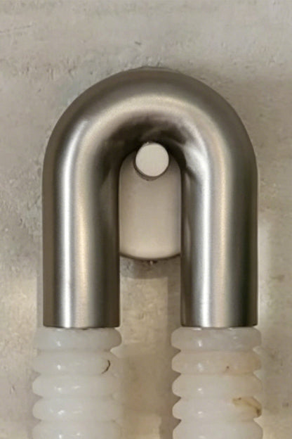 Monolith Arc Alabaster Wall Lamp | Alabaster, Metal | Close-up focus on the brushed metal U-arc and minimalist mounting point | Detail shot | vexa lamps