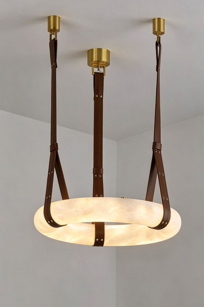 Nerissa Alabaster Ring Leather Pendant Light | Natural Alabaster, Leather and Brass | Studio shot of 3-strap ring variant illuminated on a neutral wall | vexa lamps