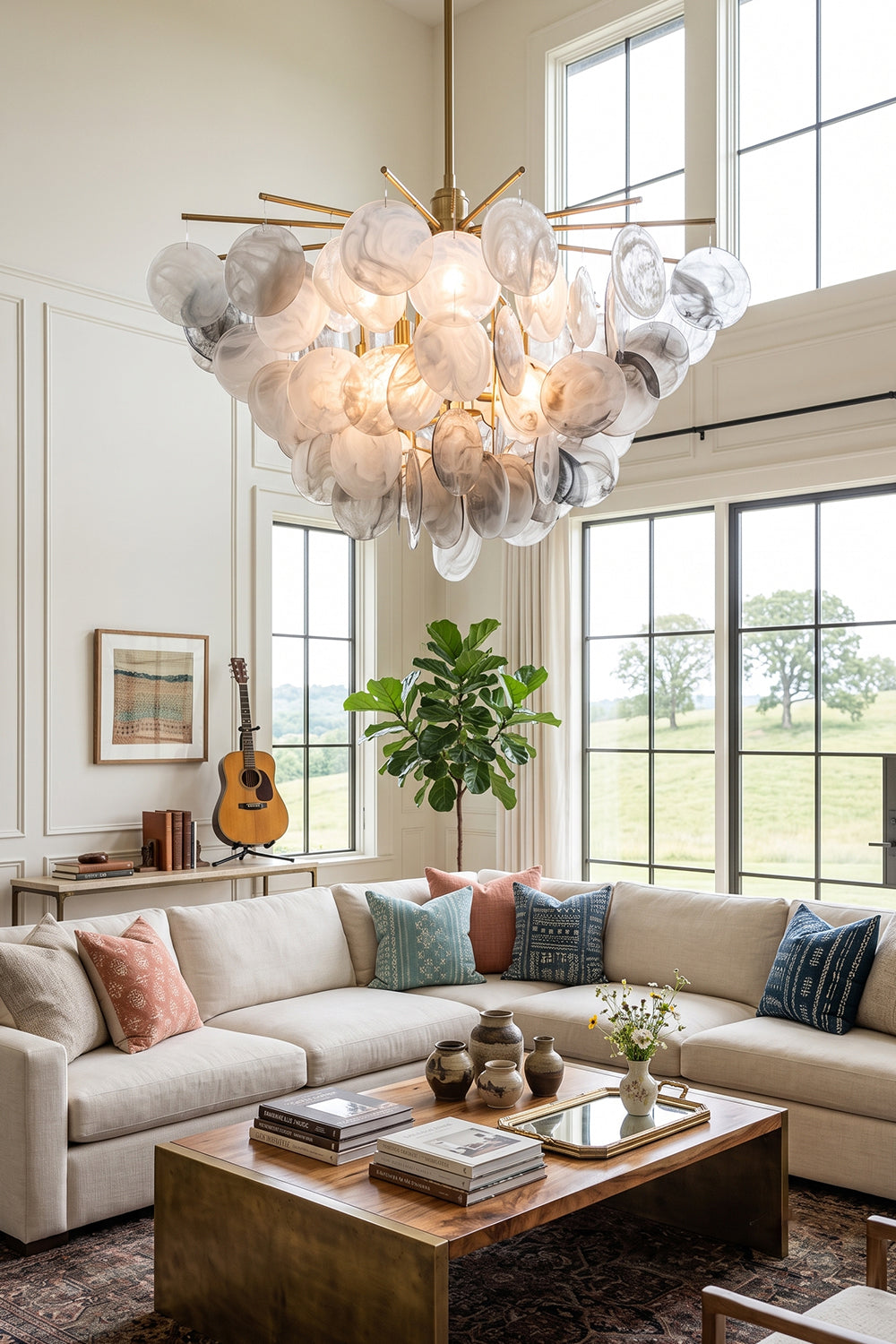 Nimbus Smoked Glass Disc Chandelier illuminates a stylish living room with modern decor and natural light.