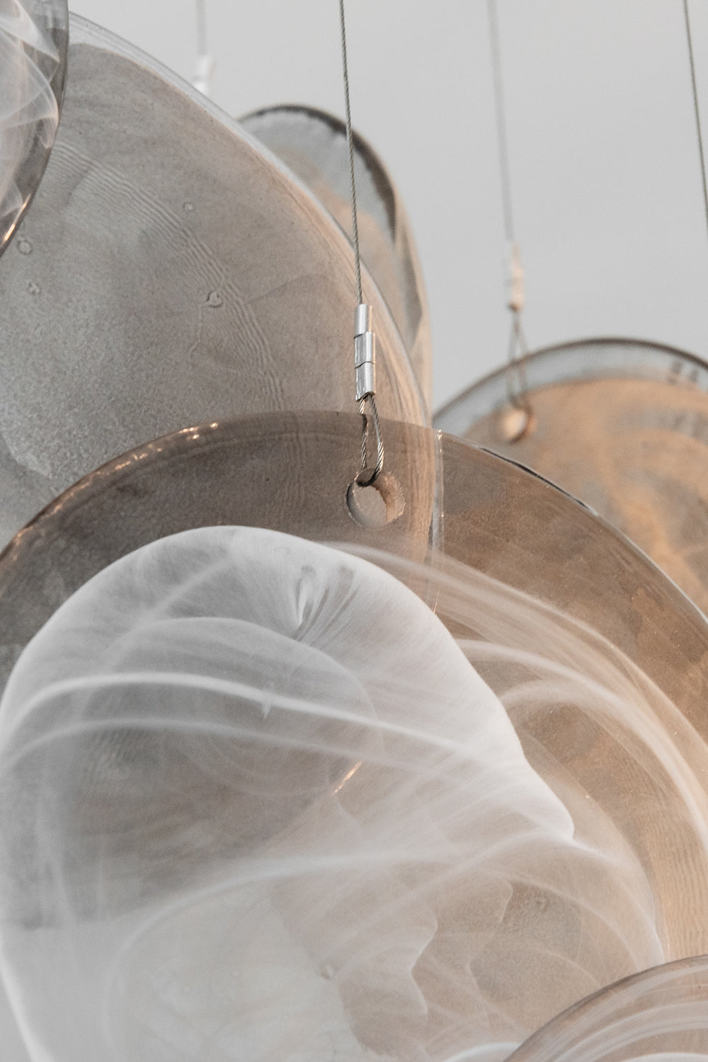 Close-up of Nimbus Smoked Glass Disc Chandelier showcasing hand-blown glass discs in a cascading design.