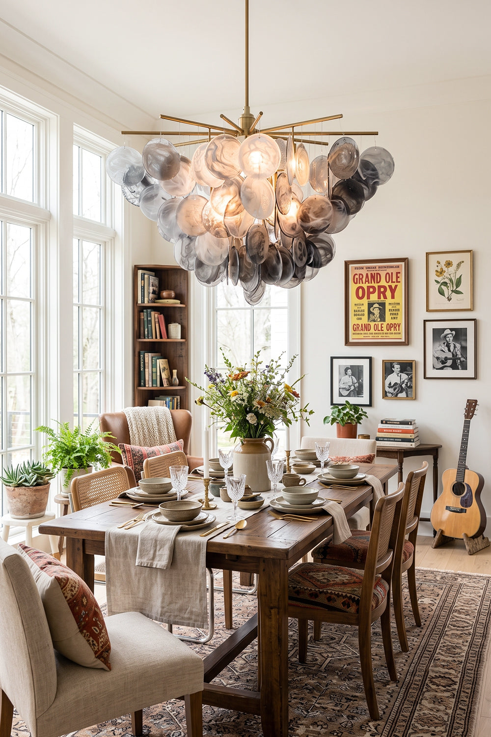 Nimbus Smoked Glass Disc Chandelier illuminating a dining room with a wooden table and floral centerpiece.