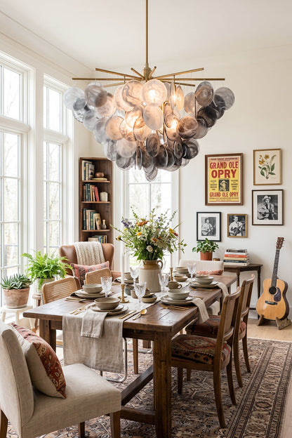 Nimbus Smoked Glass Disc Chandelier illuminating a dining room with a wooden table and floral centerpiece.