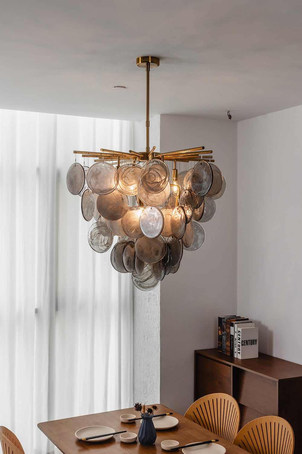 Nimbus Smoked Glass Disc Chandelier hanging above a dining table, showcasing unique hand-blown glass discs.