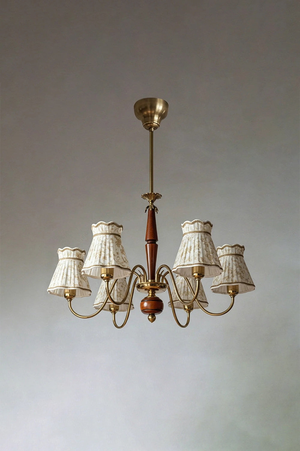 Odette Vintage Pleated Shaded Chandelier | Wood, Brass, Fabric | Studio front view of the unlit 6-light traditional shaded chandelier suspended against a plain neutral backdrop | vexa lamps
