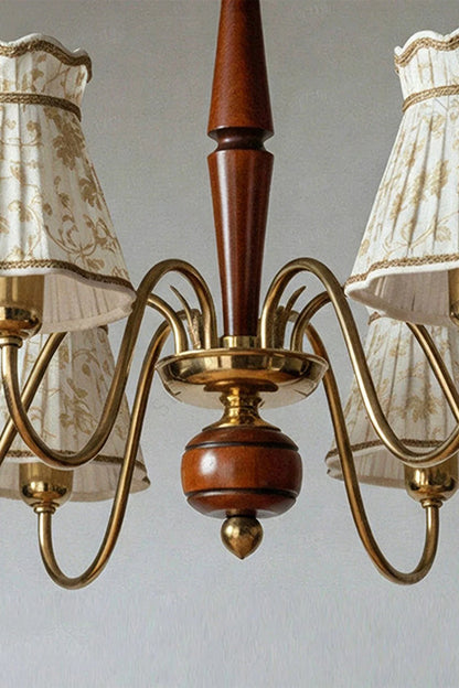 Odette Vintage Pleated Shaded Chandelier | Wood, Brass, Fabric | Close-up structural detail shot focusing on the turned wood central spindle and the ornate twisted brass scroll arm connections | Detail shot | vexa lamps