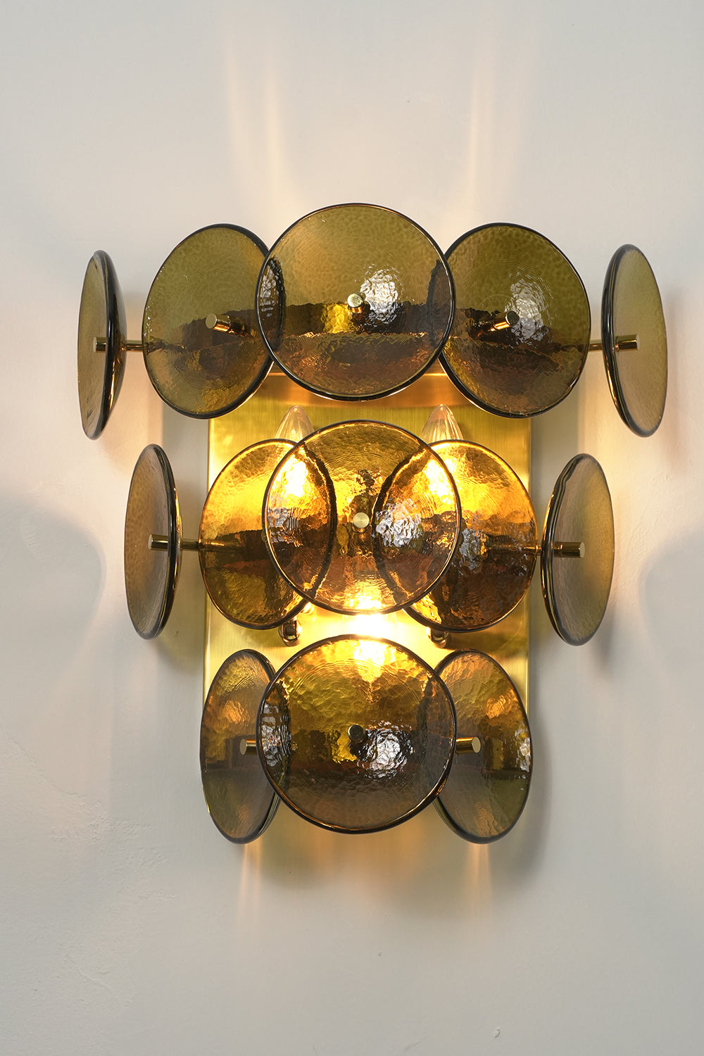 Lit tiered olive green hammered glass wall light | Metal, Glass | Angled lit product view showing tiered layers | vexa lamps