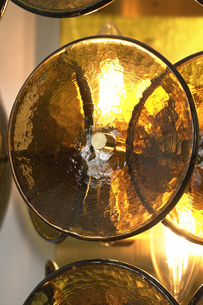 Close-up detail of lit hammered glass discs | Glass, Metal | Showing hammered texture and brass hardware connection | vexa lamps
