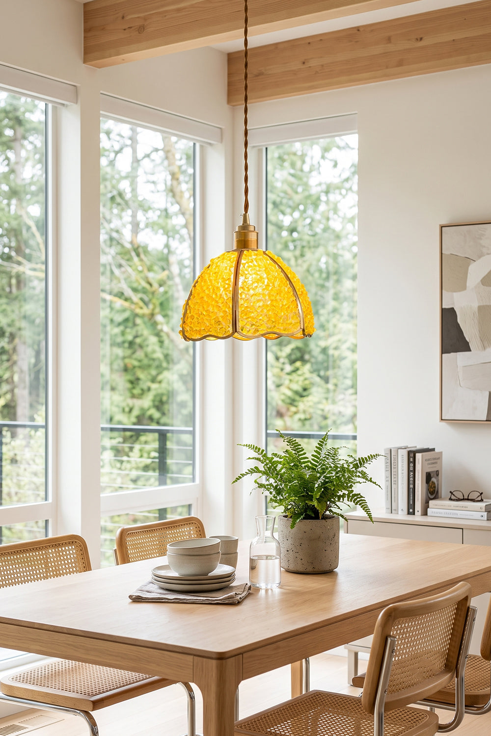 Ondine Mosaic Glass Pendant Light hanging above a wooden dining table with a plant, providing a warm glow in a bright room.