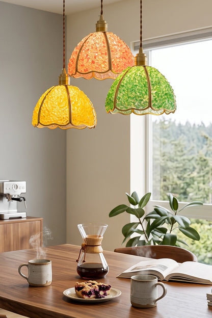 Ondine Mosaic Glass Pendant Light hanging above a kitchen table with coffee and snacks, showcasing vibrant yellow and green color.