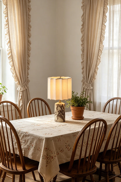 Orbis Veil Pleated Marble Table Lamp on a dining table surrounded by wooden chairs and natural light.