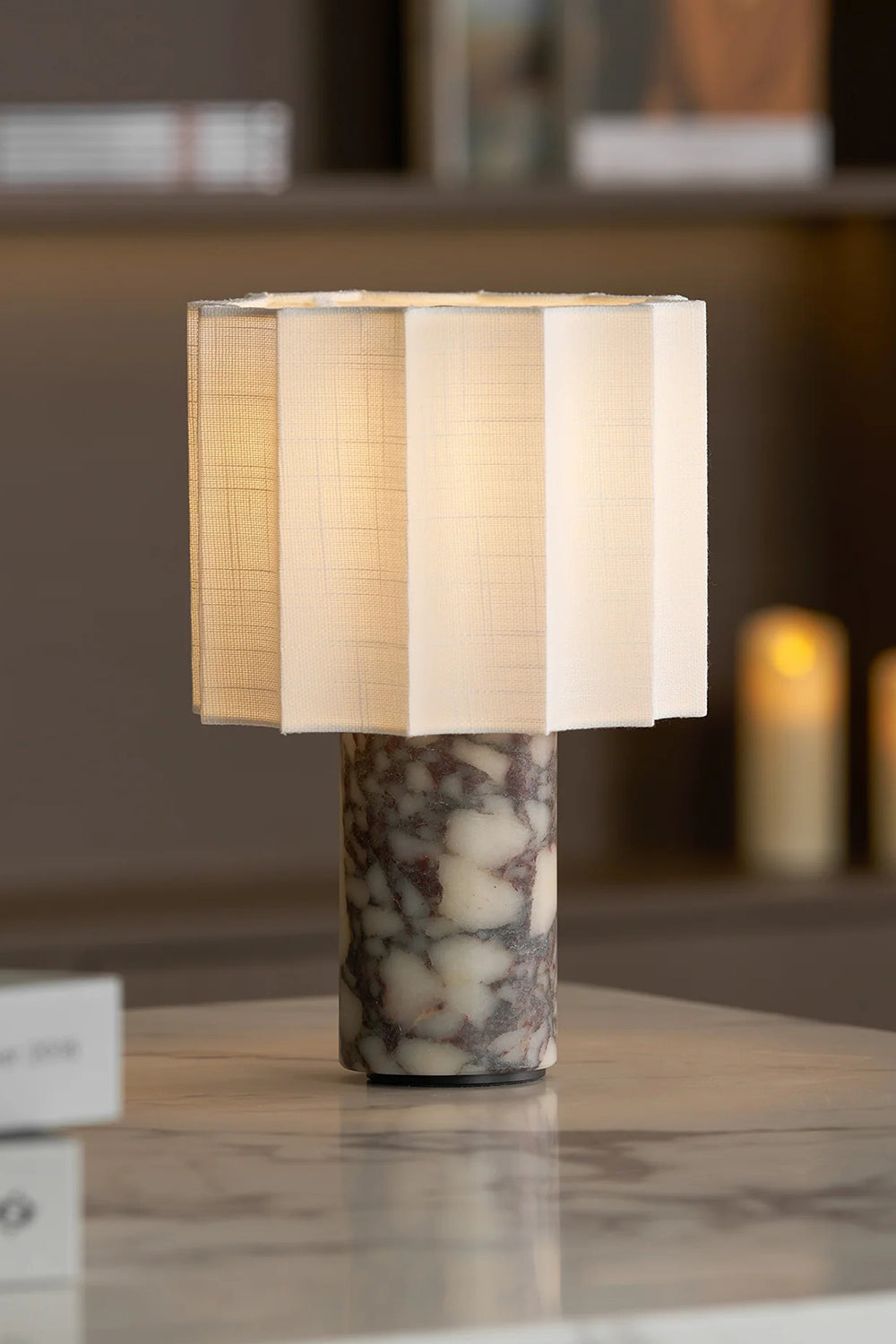 Orbis Veil Pleated Marble Table Lamp with pleated fabric shade and marble base on a table.