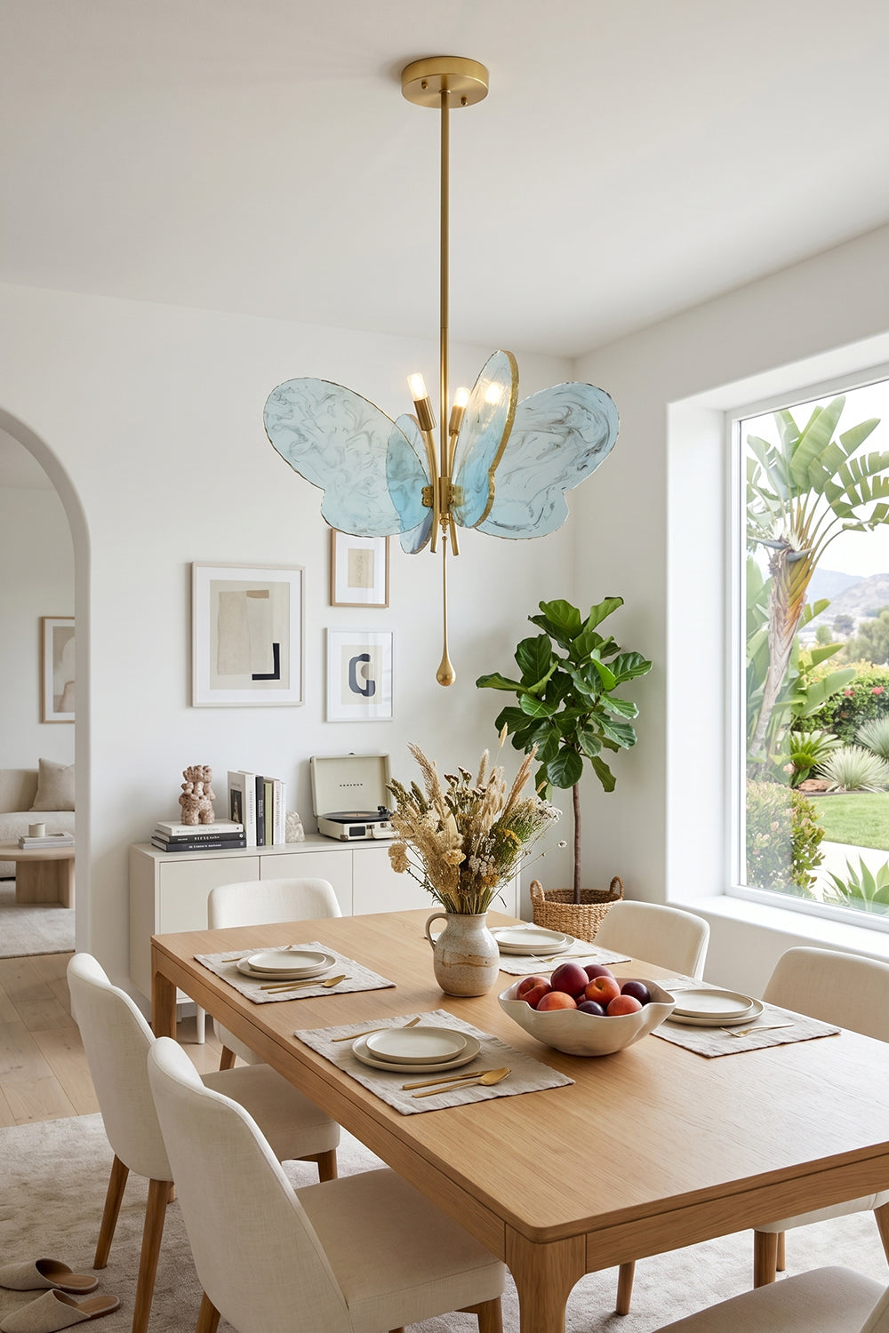 Papillon Glass Butterfly Pendant Lamp | Glass, Metal | Blue variant suspended over a light wood dining table and chairs in a contemporary sunlit dining room | vexa lamps