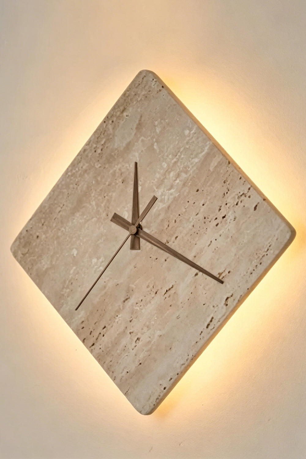 Petra Compass Travertine Backlit Wall Lamp | Travertine, Iron | Fully lit stone wall lamp radiating a warm, soft backlight halo from behind the diamond edges | Isolated lit shot | vexa lamps