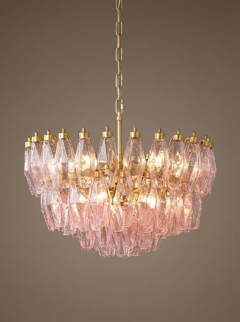 Lit pink tiered glass chandelier against dark background | Metal, Glass | Detailed front view showing the prismatic glow | vexa lamps