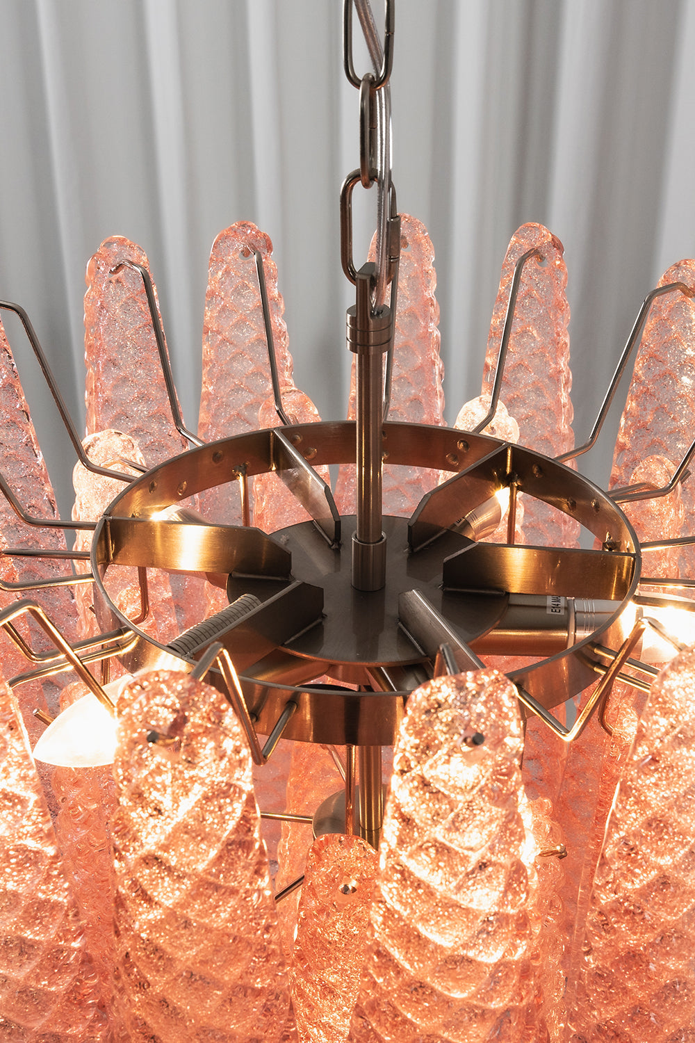 Amara Blush Cascading Glass Chandelier | Glass, Metal | Internal top-down view showing the lit bulbs and the concentric silver metal ring frame holding the glass | Detail shot | vexa lamps