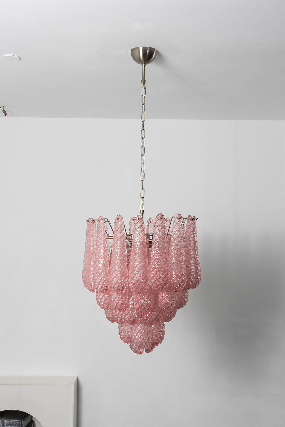 Amara Blush Cascading Glass Chandelier | Glass, Metal | Full tiered view of the illuminated pink glass chandelier casting soft ambient light against a studio backdrop | vexa lamps