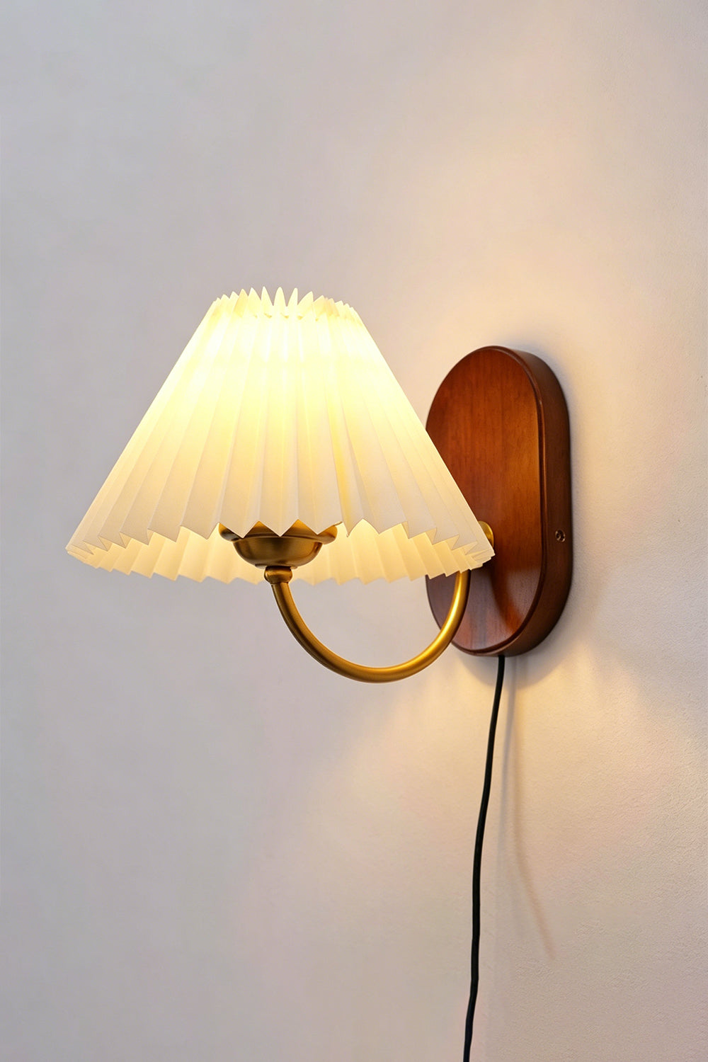 Pleated Fabric Wall Lamp | Fabric, Metal, Wood | Frontal angled view of the fully lit vintage pleated sconce throwing a warm golden backlight halo onto a neutral wall | Isolated shot | vexa lamps