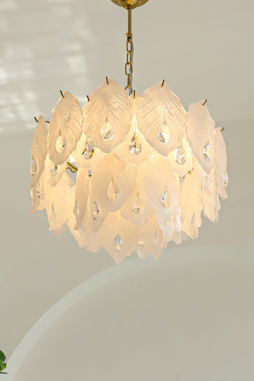 Pluma Frosted Glass Feather Chandelier | Glass, Metal | Clean front studio view of the fully illuminated glass feather fixture casting a soft warm backlight halo against a plain background | vexa lamps