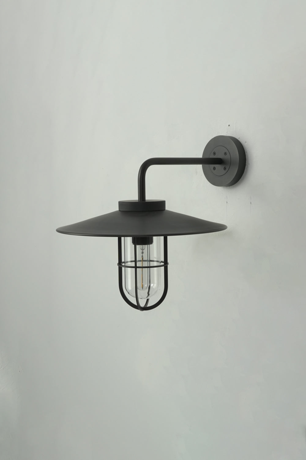 Side profile of black Portree wall light | Metal, Glass | Mounted on a wall showing the gooseneck shape | vexa lamps