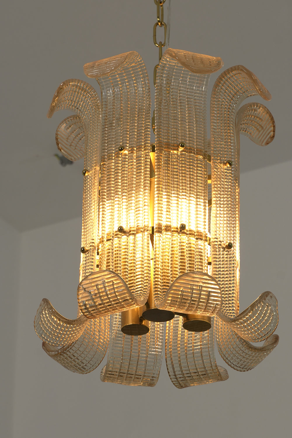 Internal brass frame and curved glass scroll panels | Metal | Glass | Side profile view showing the chandelier's intricate construction | vexa lamps