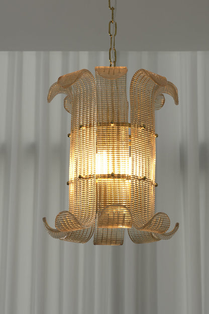 Lit ribbed glass scroll chandelier against white curtain | Metal | Glass | Front view showing the elegant scroll shape and warm glow | vexa lamps