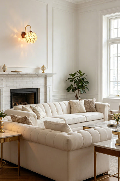 Rosalind Petal Glass Botanical Wall Lamp | Glass, Metal, Wood | Positioned elegantly over a fireplace in a bright minimalist living space with a white sectional sofa | vexa lamps