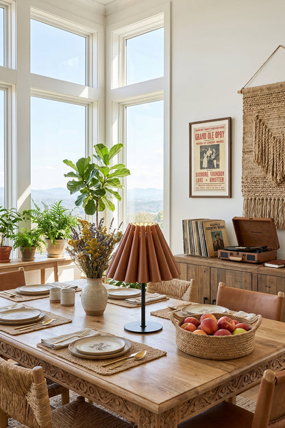 Rowan Leather Pleated Table Lamp | Leather, Metal | Serving as an elegant centerpiece on a long wooden dining table set in a sunlit corner dining room | vexa lamps