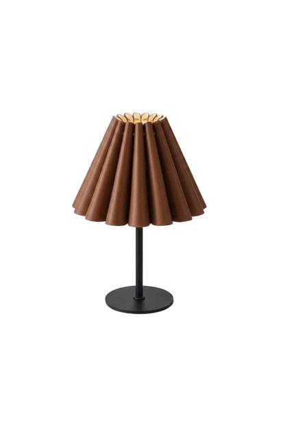 Rowan Leather Pleated Table Lamp | Leather, Metal | Fully lit minimalist table lamp featuring a brown pleated accordion leather lampshade, a slender black stem, and a flat round base | Isolated lit product shot on white background | vexa lamps