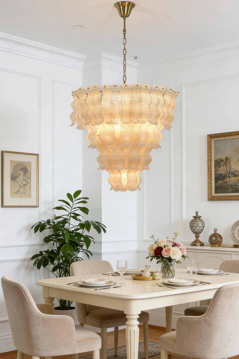 Ruffled tiered glass chandelier over dining table | Metal | Glass | Centered in a formal dining room with beige chairs | vexa lamps