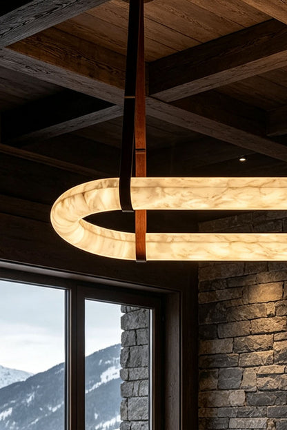 Selwyn Racetrack Alabaster Leather Pendant Light | Natural Alabaster, Leather and Metal | Close-up detail of the illuminated alabaster ring near a scenic window | vexa lamps