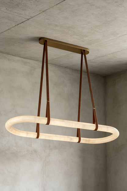 Selwyn Racetrack Alabaster Leather Pendant Light | Natural Alabaster, Leather and Metal | Front illuminated view of the oval alabaster pendant on a neutral wall | vexa lamps