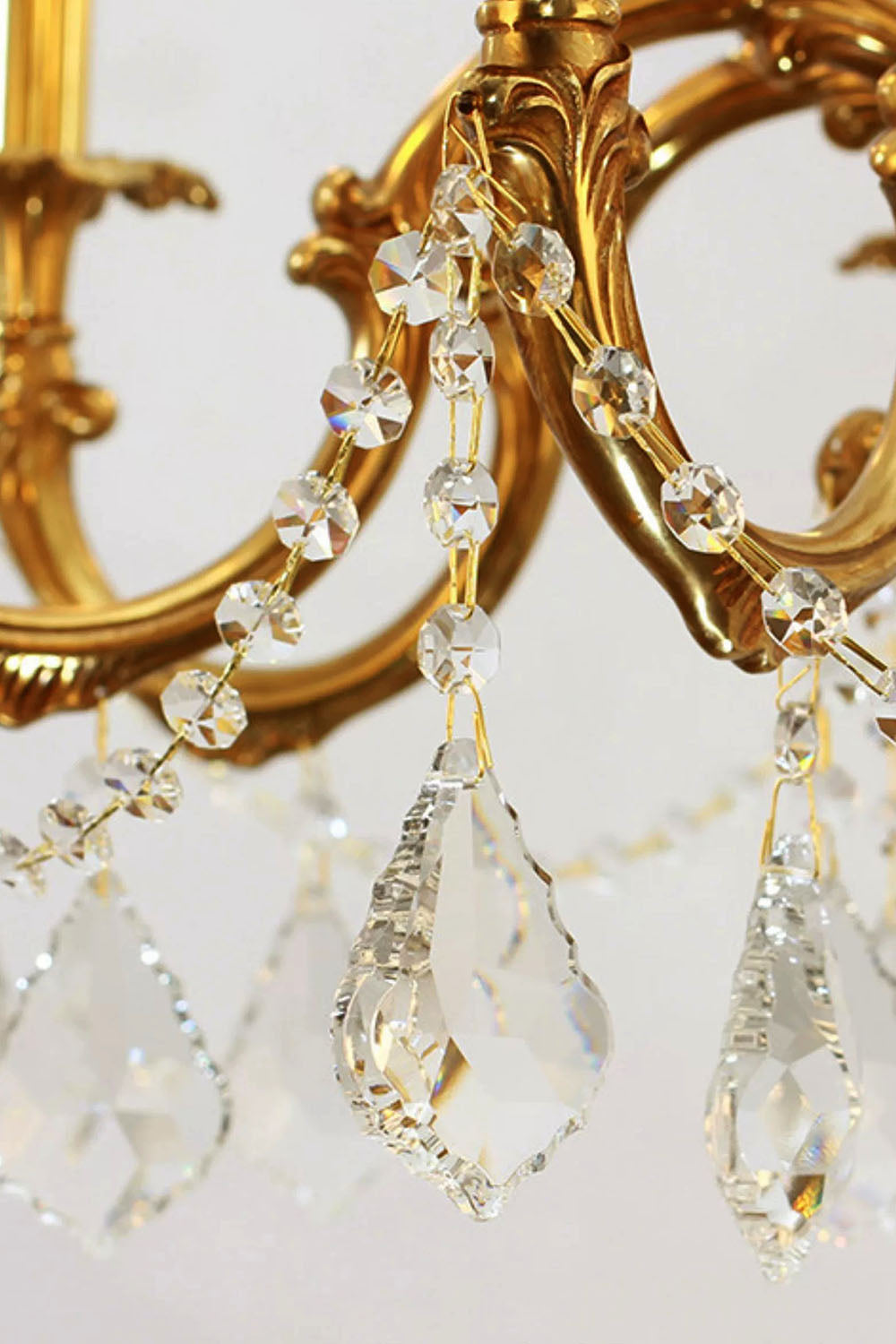 Detail view of the Sidonie Scrolled Brass Crystal Chandelier showcasing elegant crystal drop accents.