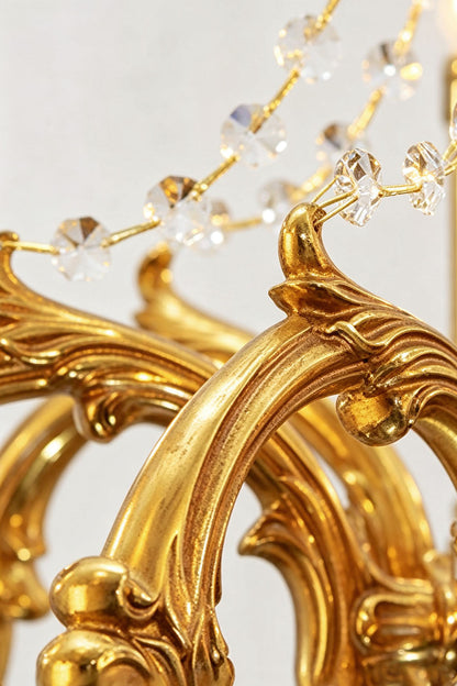 Close-up of the decorative details on the Sidonie Scrolled Brass Crystal Chandelier showcasing its luxurious design.