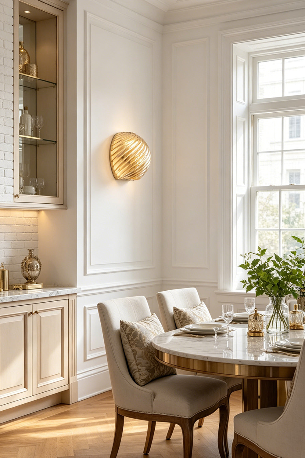 Silas Ribbed Glass Wall Sconce | Ribbed Glass, Metal | Installed as sophisticated ambient lighting in a refined classical dining room casting a warm gold glow next to a table set | vexa lamps