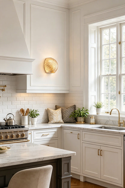 Silas Ribbed Glass Wall Sconce | Ribbed Glass, Metal | Illuminating a bright classical kitchen wall, casting a warm golden light halo near white cabinetry and marble counters | vexa lamps