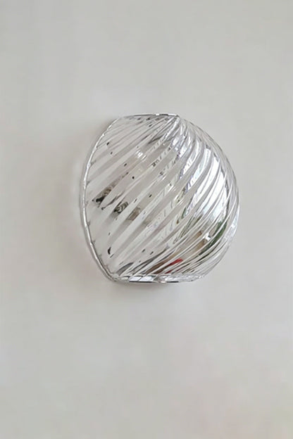 Silas Ribbed Glass Wall Sconce | Ribbed Glass, Metal | Studio unlit view of the clear silver ribbed glass finish variant showcasing its organic pebble silhouette against a plain backdrop | vexa lamps
