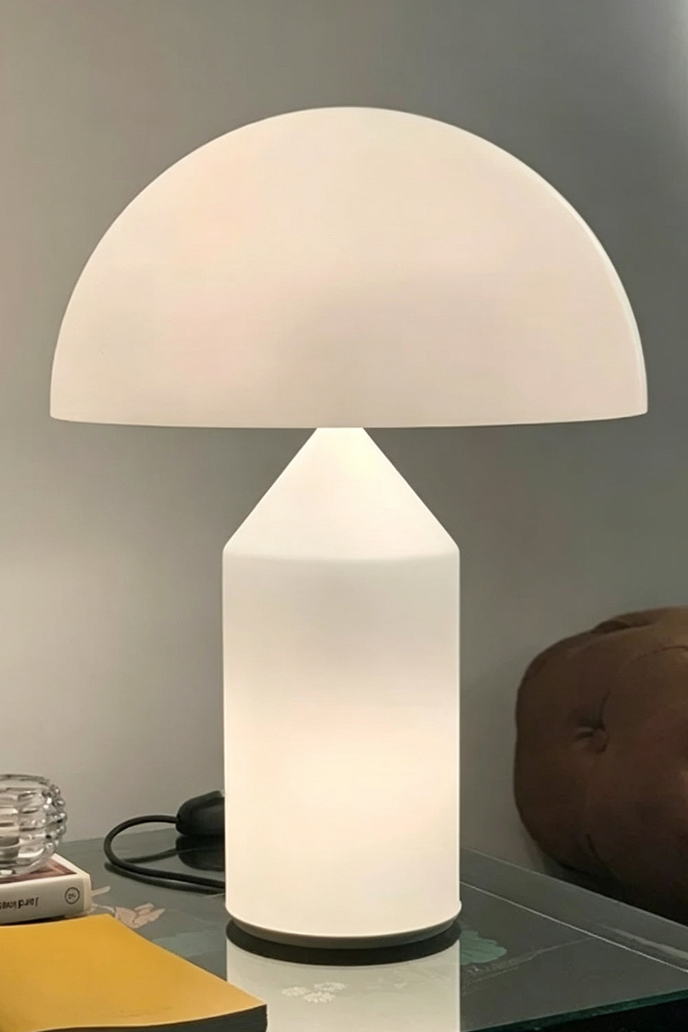 Solene Domed Glass Table Lamp | White Frosted Glass | Close-up shot of the mushroom lamp glowing softly on a dark reflective glass table surface | vexa lamps