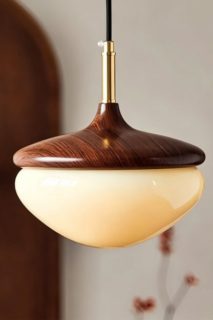 Soren Wood Grain Pendant Lamp | Wood, Glass, Metal | Detailed shot of the hanging mid-century pendant lamp illuminated against a warm neutral backdrop | vexa lamps