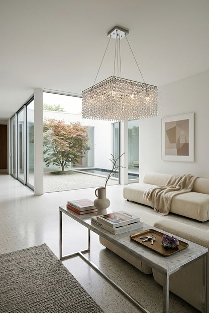 Sparkling crystal chandelier in an open-plan lounge | Stainless Steel, Crystal | Bright interior scene with large sliding glass doors | vexa lamps