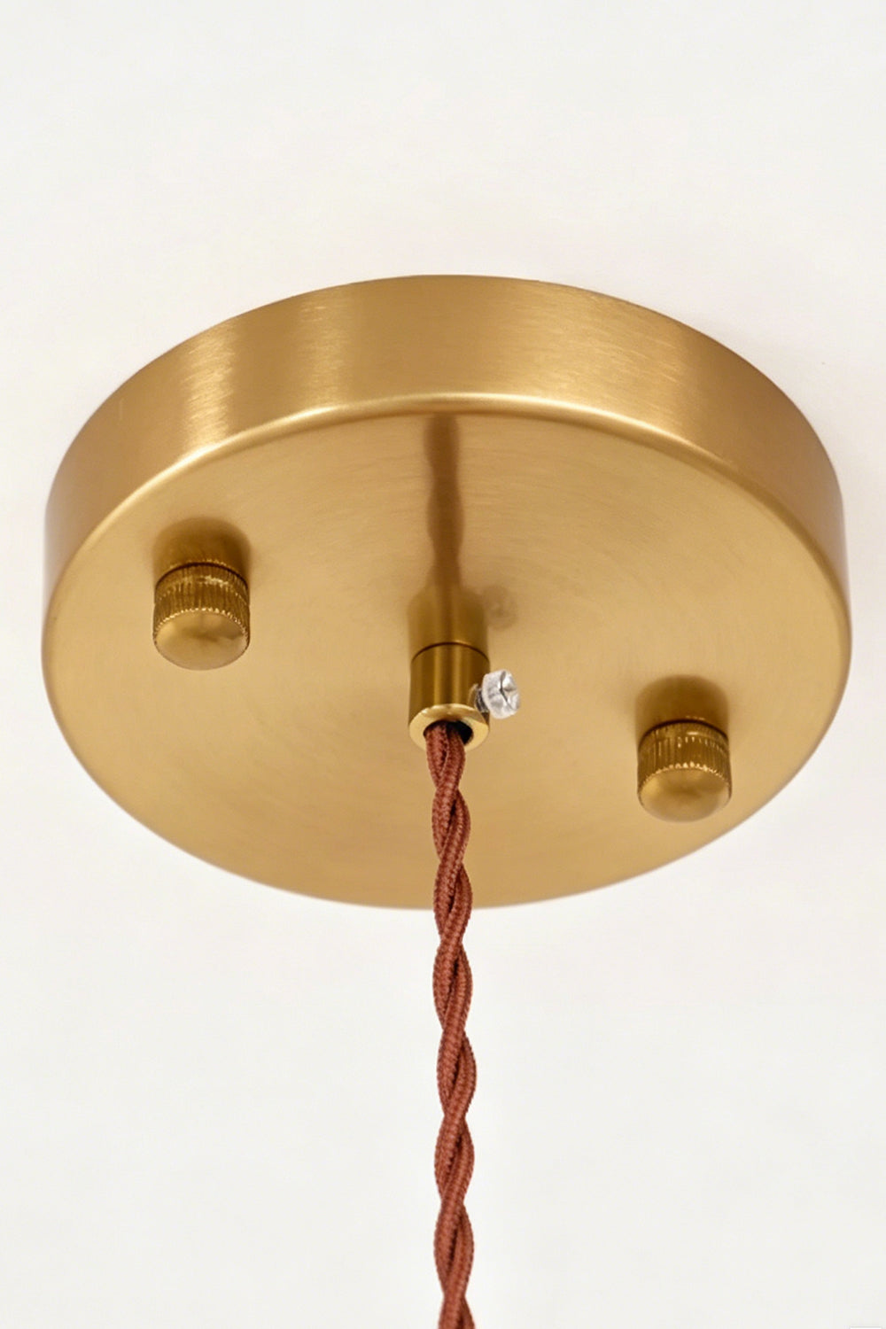 Speckled Bubble Glass Pendant Lamp | Glass, Metal | Close-up view of the circular brushed brass ceiling canopy and a brown twisted fabric electrical cord | Detail shot | vexa lamps