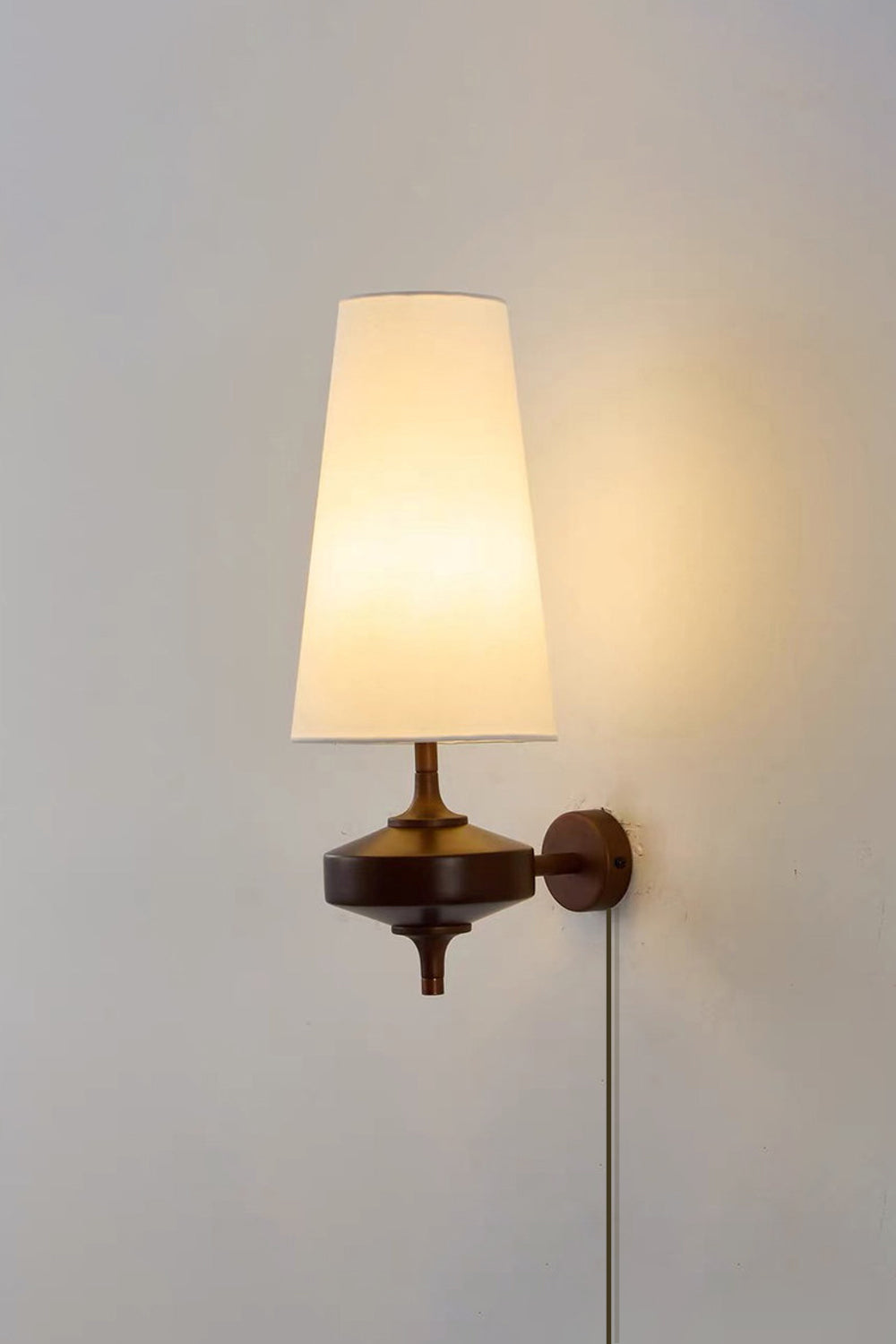 Spindle Walnut Wood Wall Sconce featuring a tapered shade and antique brass details, ideal for accent lighting.