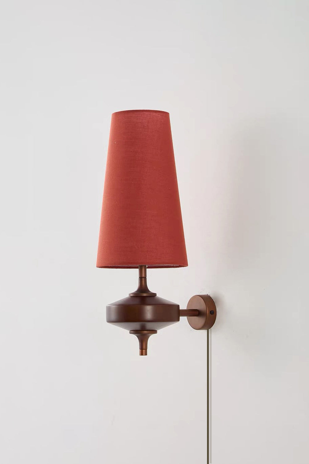 Spindle Walnut Wood Wall Sconce featuring a terracotta fabric shade and antique brass accents.