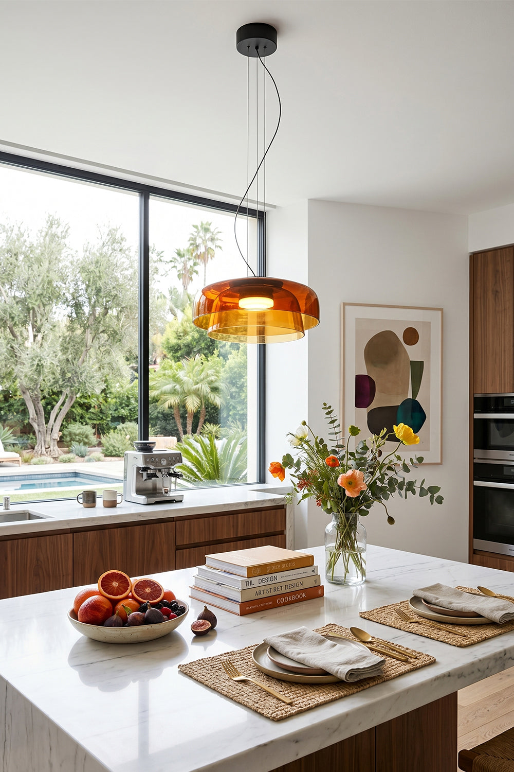 Stratum Layered Glass Pendant Light | Glass, Metal | Orange variant hanging as a warm centerpiece over a modern white kitchen island with flowers | vexa lamps