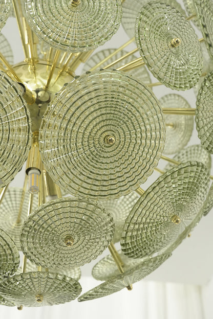Detailed close-up of unlit green glass sunburst discs | Metal, Glass | Showing texture and brass attachment hooks | everlamps