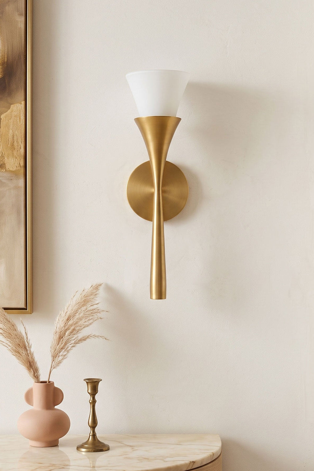 Sylvain Modern Torch Wall Sconce featuring a trumpet-shaped metallic stem and frosted glass shade on a wall.