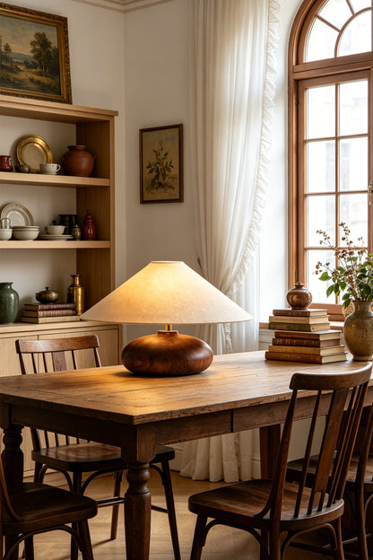 Sylvan Oval Walnut Table Lamp | Wood, Fabric, Metal | Illuminating a rustic wooden dining table surrounded by classic wooden chairs | vexa lamps