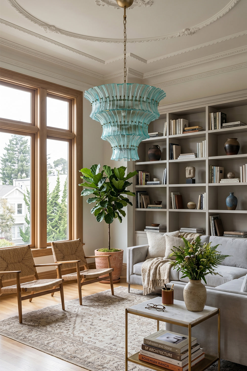 Thalassa Aquamarine Textured Glass Chandelier | Glass, Metal | Providing a cozy colorful glow in a contemporary living space decorated with built-in bookcases, white couches, and plants | vexa lamps